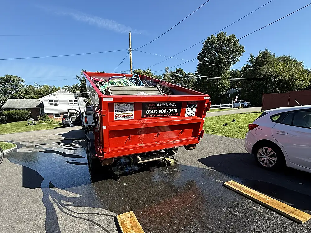 Wood protection boards laid on an asphalt driveway before dumpster placement — 845 Dump 'N Haul, Dutchess County NY
