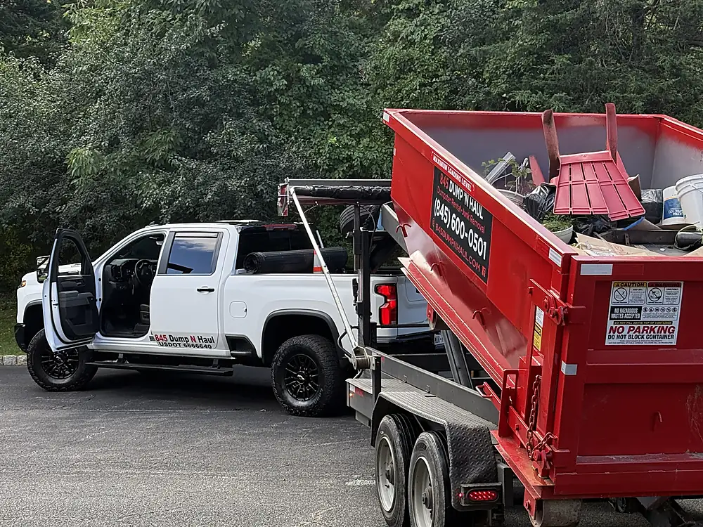 Loaded dumpster being picked up and loaded onto the trailer in Poughkeepsie, NY — 845 Dump 'N Haul