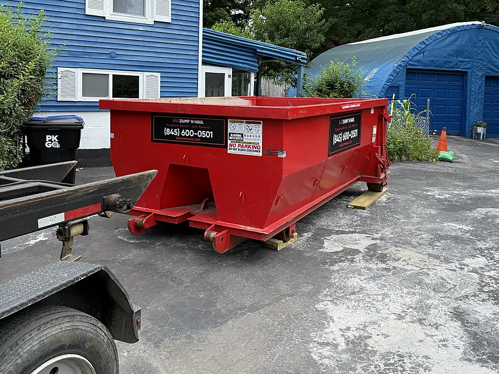 Red roll-off dumpster on a residential driveway in Newburgh, NY — 845 Dump 'N Haul