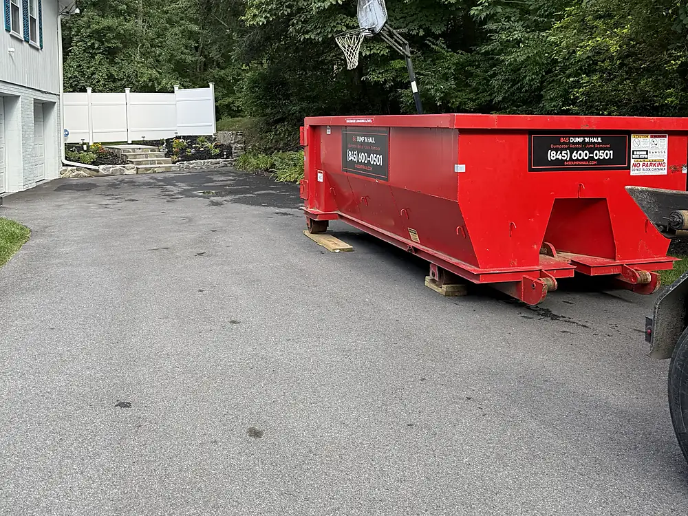 Red dumpster placed on a residential driveway in Newburgh, NY — 845 Dump 'N Haul